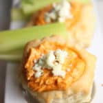 cheesy buffalo chicken cheese dip in puff pastry with cheese sprinkled on top and celery stick.