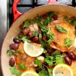 Overhead image of pot on stove with chicken, olive and lemon dish