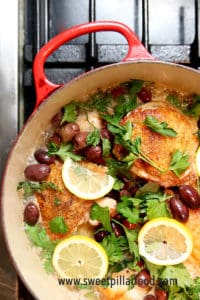 Overhead image of pot on stove with chicken, olive and lemon dish